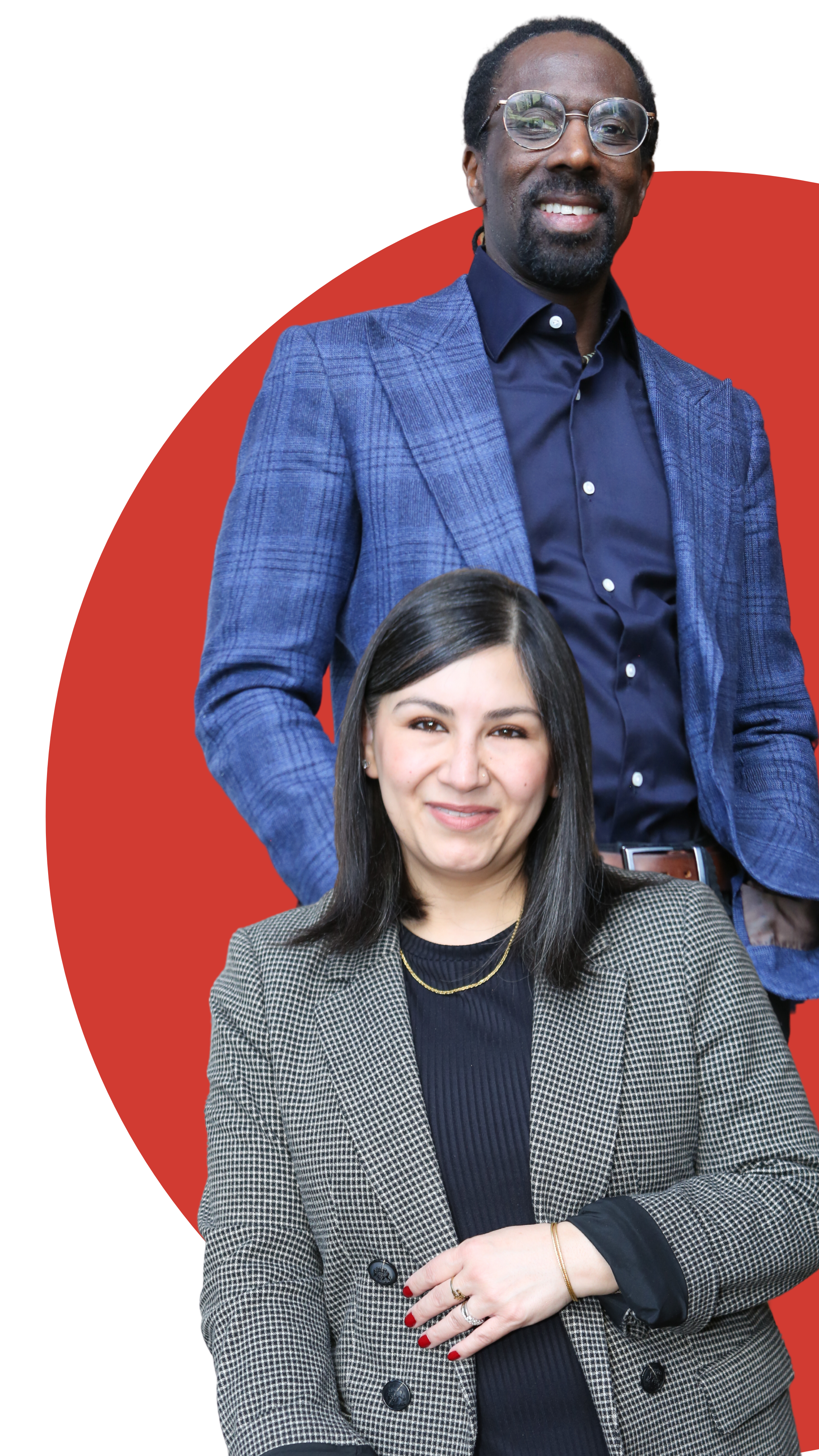 Two people pose confidently. The person in front wears a plaid blazer, and the person behind wears a blue blazer with glasses, set against a red circular background.